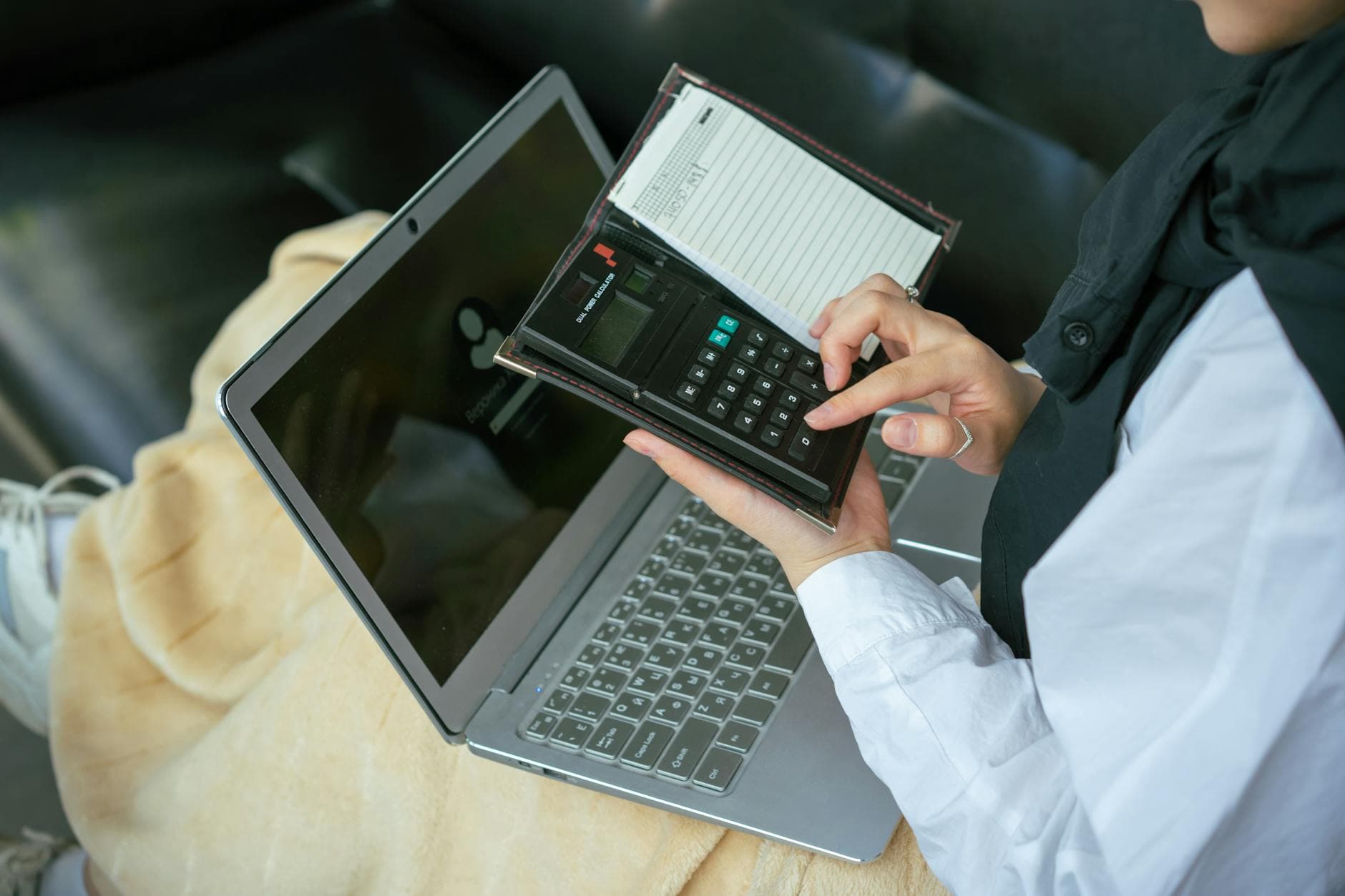 Agency founder reviewing MTD bridging software options on a laptop in a modern UK office with spreadsheet visible on screen
