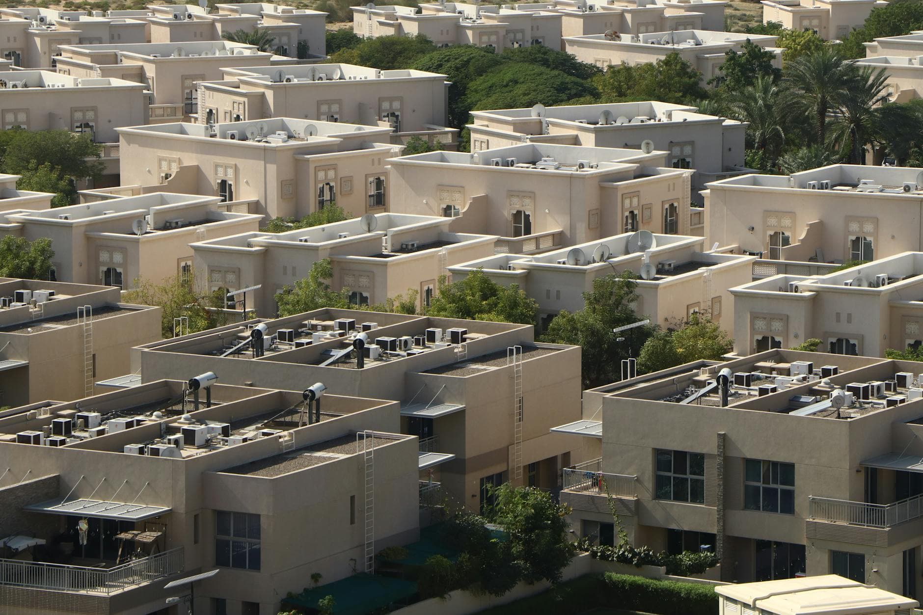 Agency founder family looking at a modern Dubai apartment with skyline view, discussing relocation costs and school fees