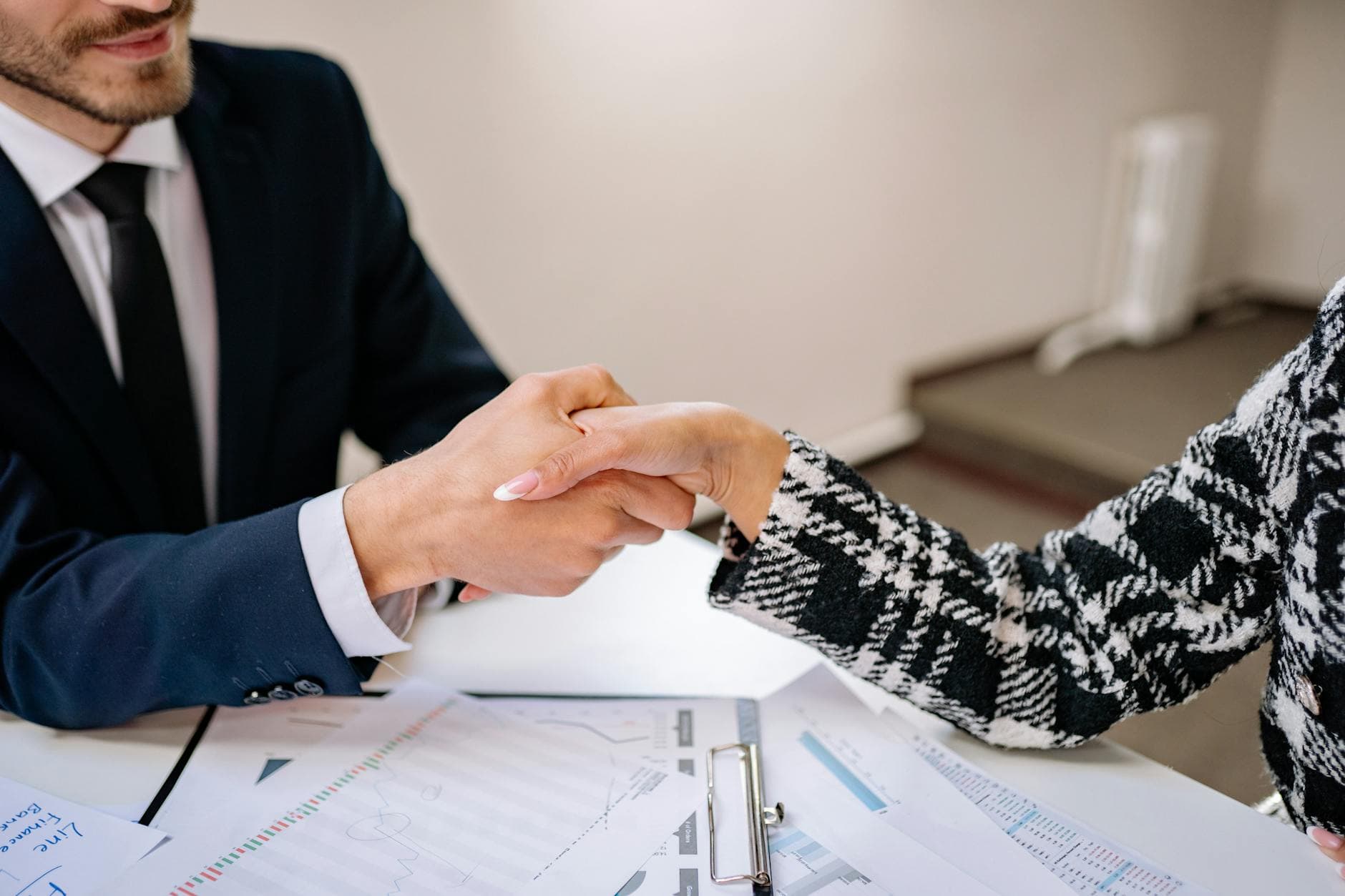 Two agency founders reviewing a retainer contract document in a modern UK office meeting room