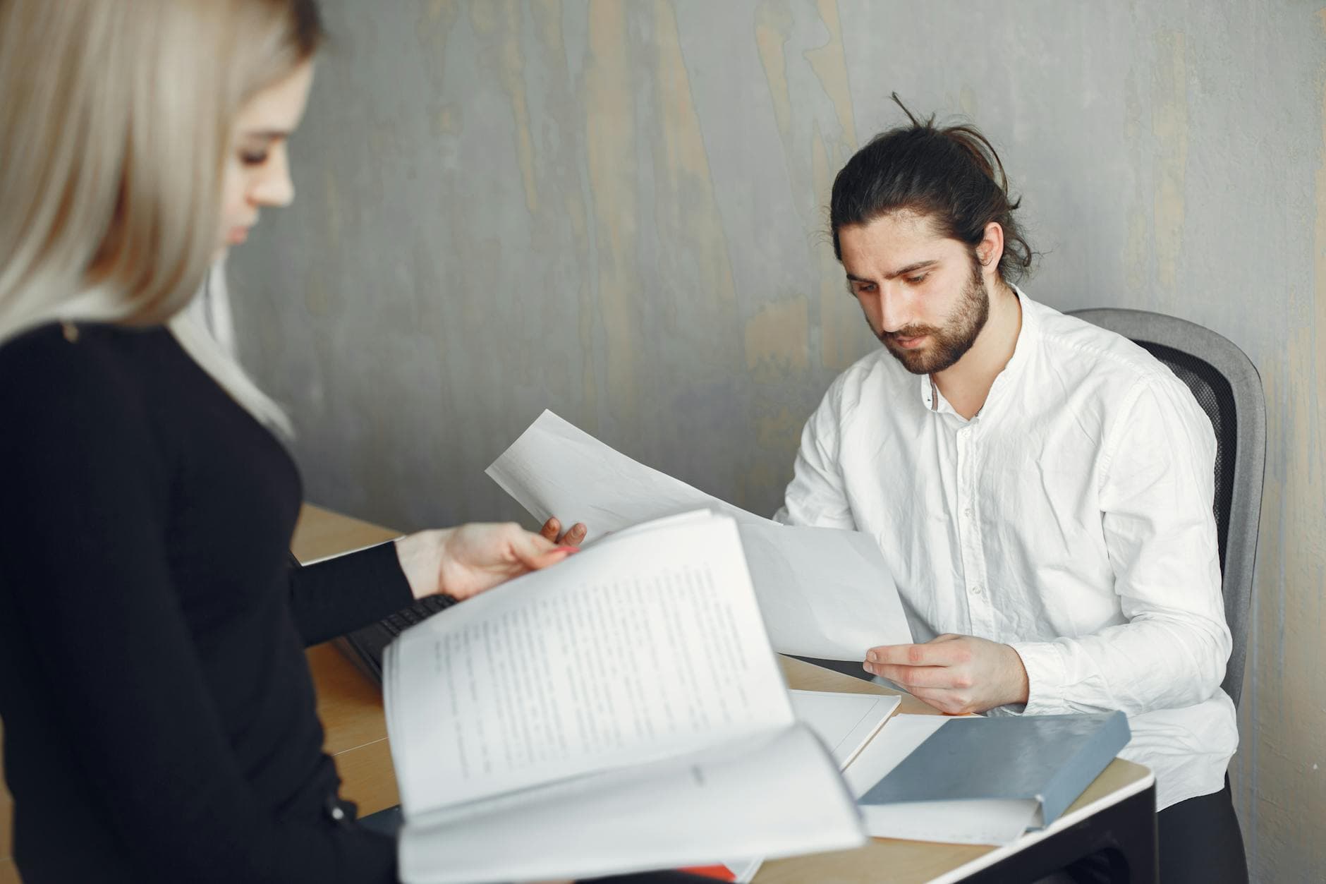 Agency founder reviewing payroll documents on a laptop in a modern UK office