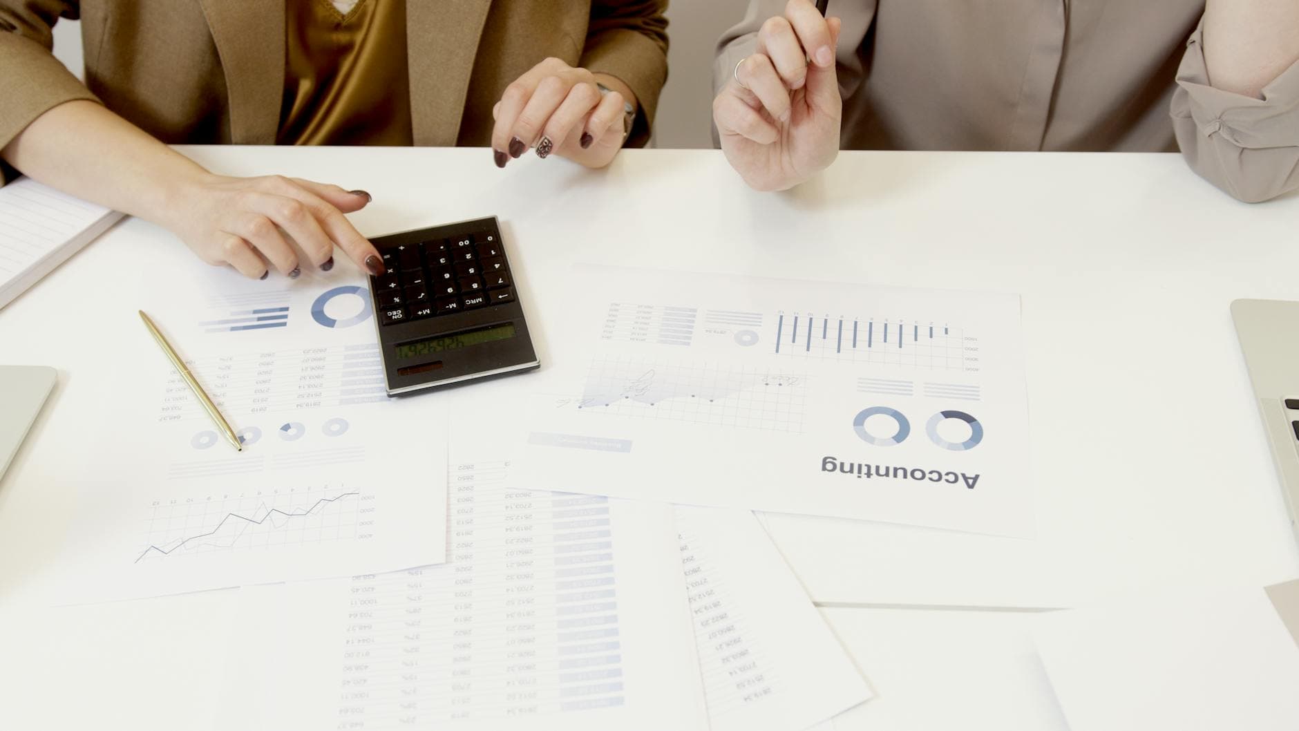 Two agency founders reviewing financial reports with their specialist accountant in a modern London office