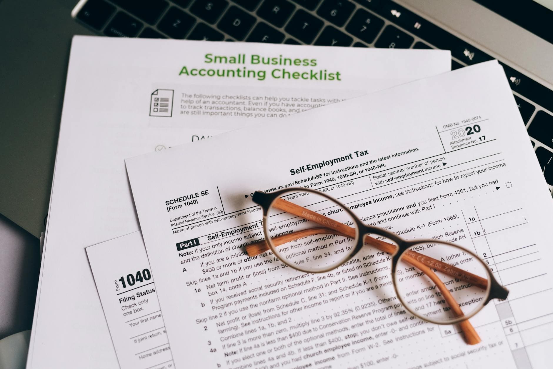 UAE agency founder reviewing corporate tax documents in a Dubai office with laptop and paperwork