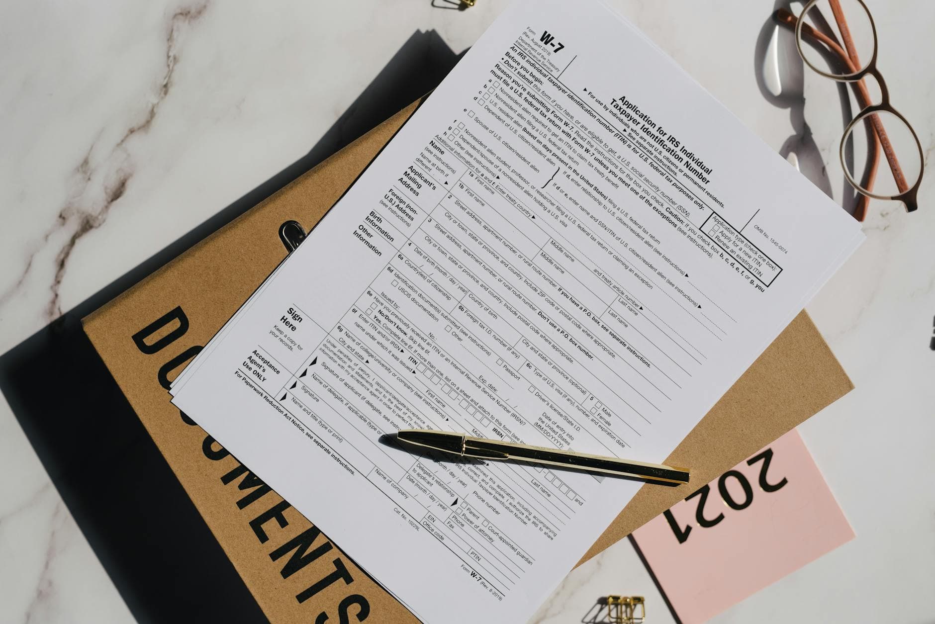 UK agency founder reviewing a UAE retainer contract with a calculator and VAT registration forms on a desk in a Dubai office setting
