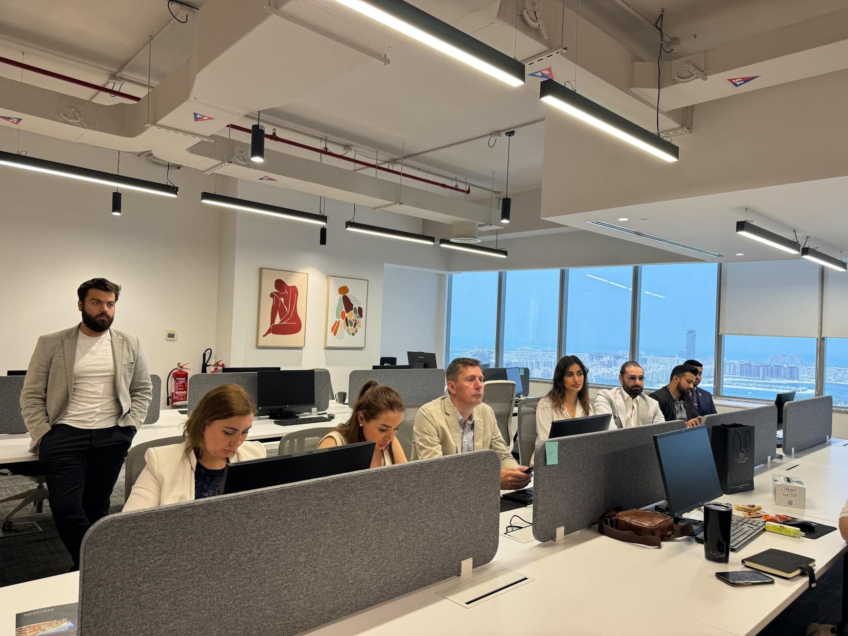 Two agency founders reviewing paperwork in a Dubai free zone office with skyline visible through window