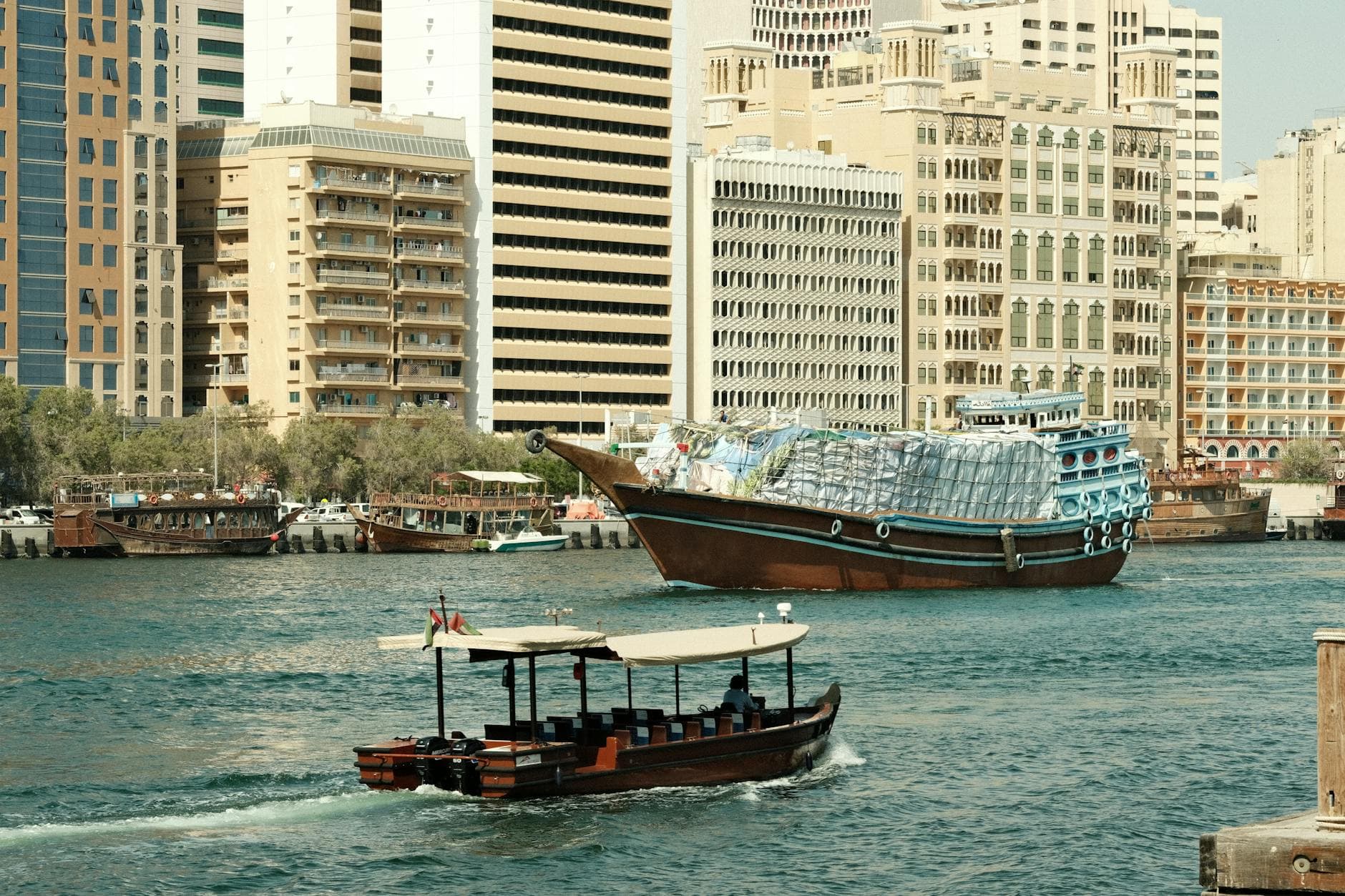 UK pension paperwork on a desk next to a Dubai skyline photo, illustrating the overseas transfer charge trap for agency founders