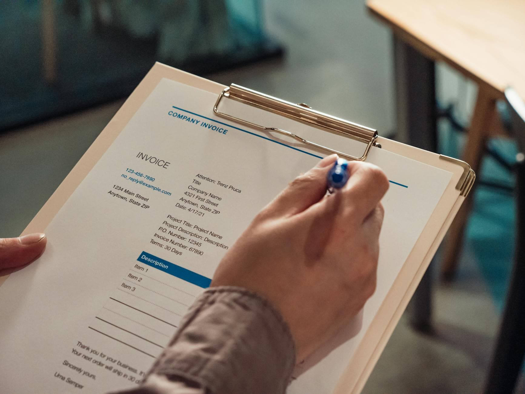 UK accountant reviewing VAT invoices for agency freelancer subcontractor costs at a desk in a Manchester office